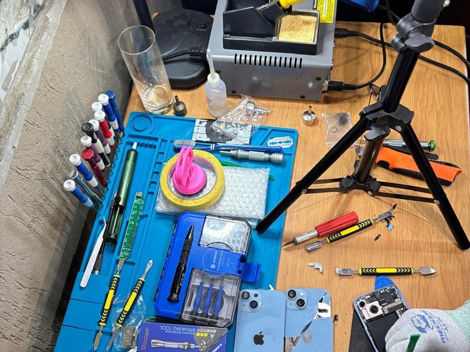 Lai Lai Pro repair bench with tools and iPhones being repaired
